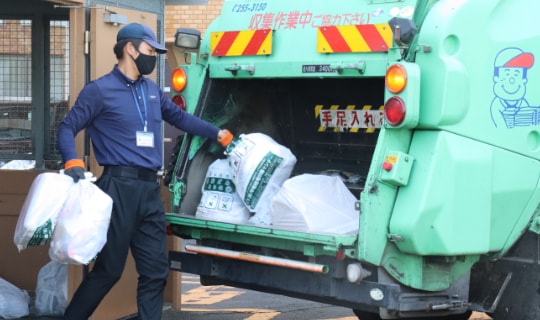 ゴミ収集車にてゴミを収集している画像